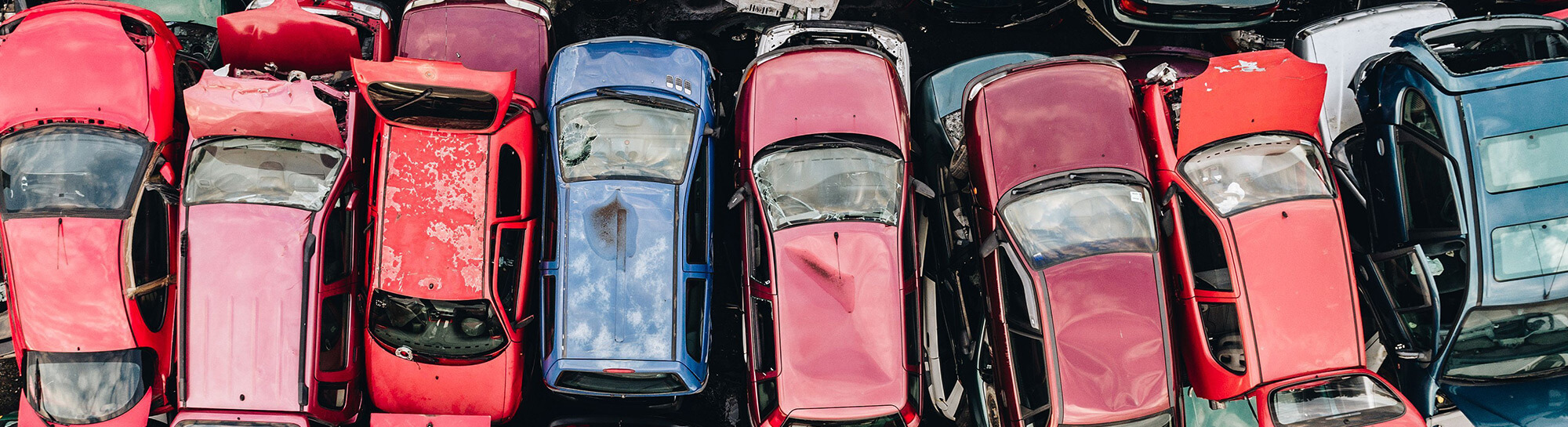 Aerial photo of rows of scrapped cars, trucks and vans